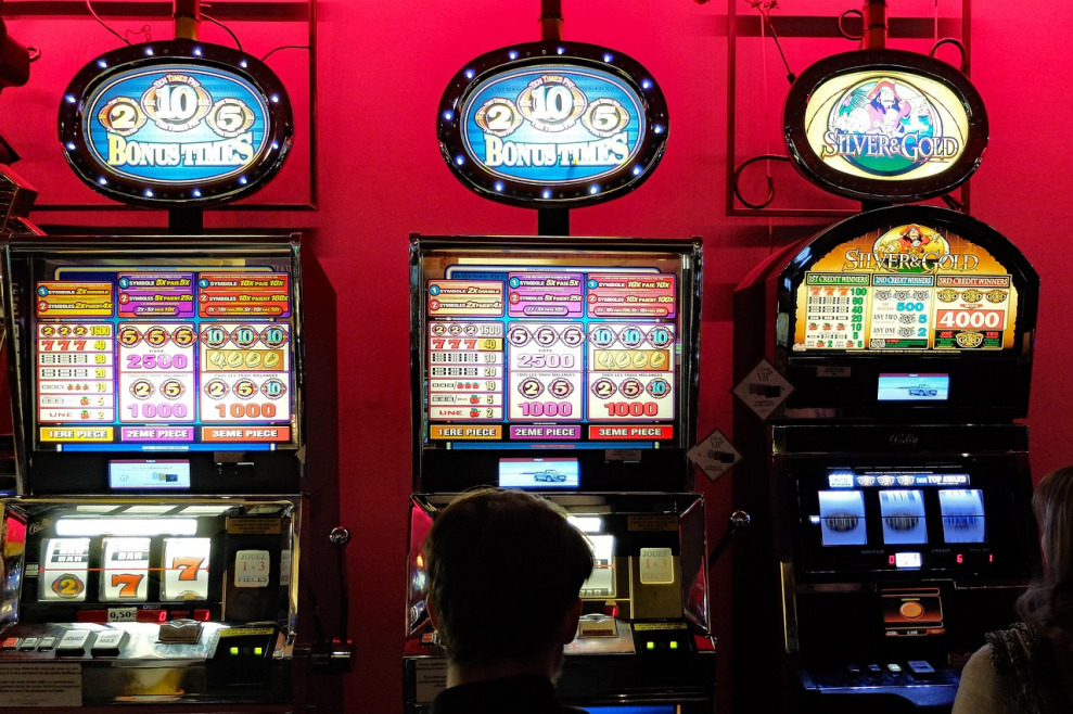 Rows of modern MicroGaming online slot machines glowing in a casino game room